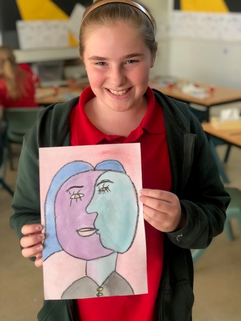 a photo of a child with her finished piece of art