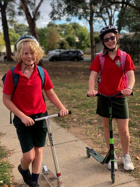 a photo of children riding their scooters