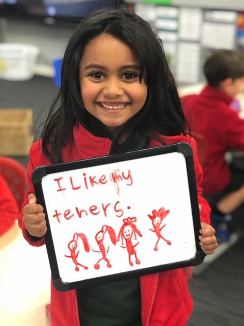 A photo of a child with a whiteboard