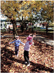 2 kids play under the tree