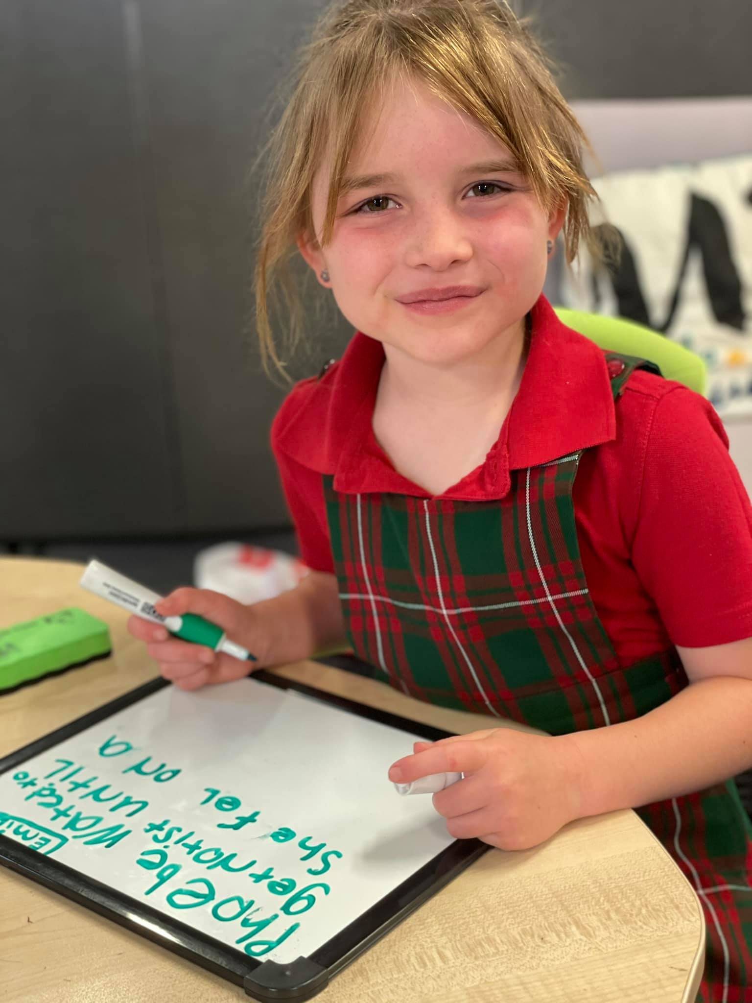 A photo of a child with a whiteboard